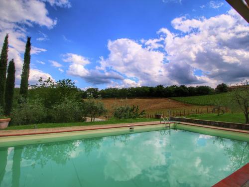 ブーチネにあるBelvilla by OYO Holiday home with pool in Tuscanyの青空と雲のあるスイミングプール