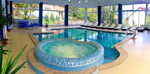 a large swimming pool with a tub in a building at Alva Hotel & Spa in Tsaghkadzor