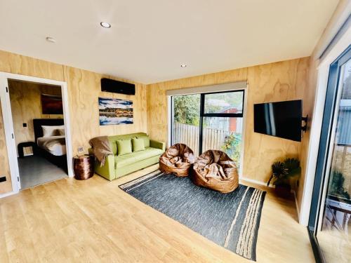 a living room with a couch and a television at Rivers Edge Apartment in Lake Tekapo