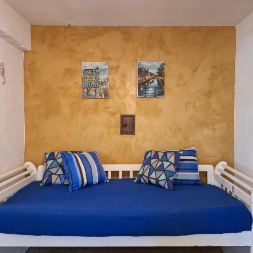 a bedroom with a blue bed with two pillows at Casas Loft Búzios in Búzios
