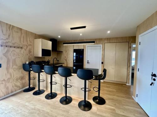 a kitchen with blue bar stools in a room at Rivers Edge Villa in Lake Tekapo