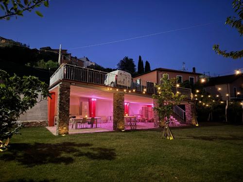 a house with a deck at night with lights at Ligo in Villanova dʼAlbenga