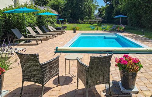 a swimming pool with chairs and a table and umbrella at Amazing Home In Thierville in Thierville