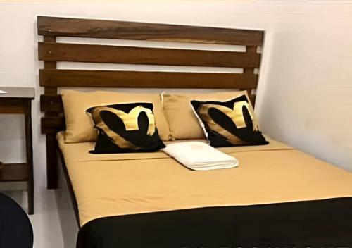 a bed with black and white pillows on it at Malibhu View Resort 