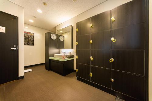 a bathroom with wooden lockers and a sink in it at Super Hotel JR Shin-Osaka Higashiguchi in Osaka