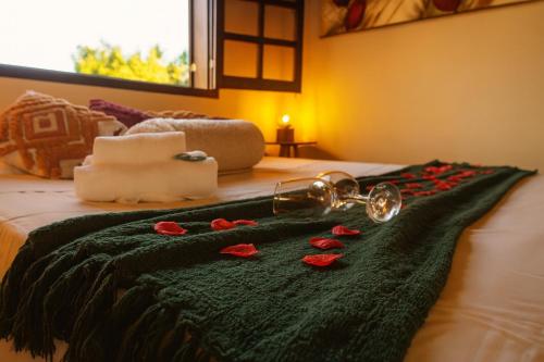 a bed with red roses on a black blanket at Pousada Bella Vista in Serra do Cipo