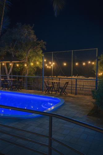 a swimming pool at night with lights on a fence at Pousada Bella Vista in Serra do Cipo