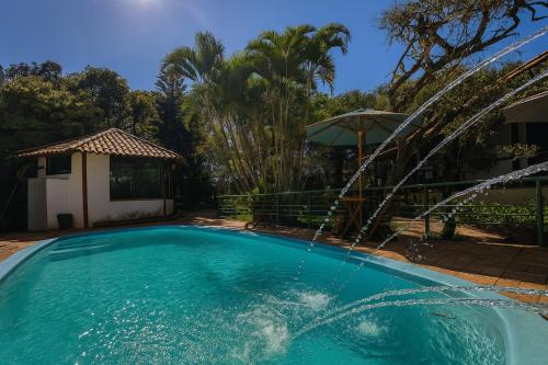 a swimming pool with a water fountain at Pousada Bella Vista in Serra do Cipo
