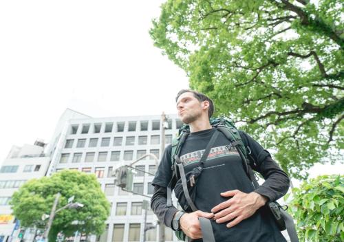 a man with a backpack standing in front of a building at Super Hotel JR Shin-Osaka Higashiguchi in Osaka