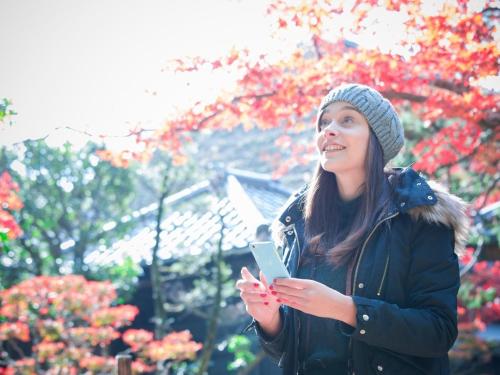 a woman is looking at her cell phone at Super Hotel JR Shin-Osaka Higashiguchi in Osaka