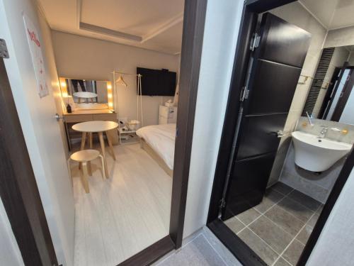 a small room with a bed and a sink at Bom Stay in Seoul