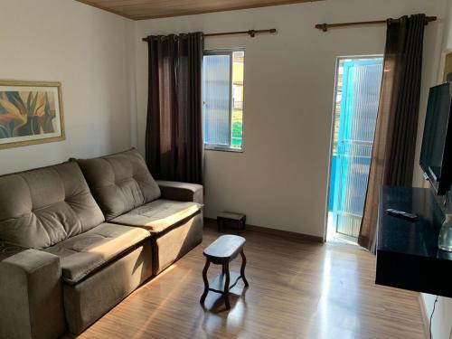 a living room with a couch and a table at Apartamento Aconchegante no Bairro Alto in Teresópolis