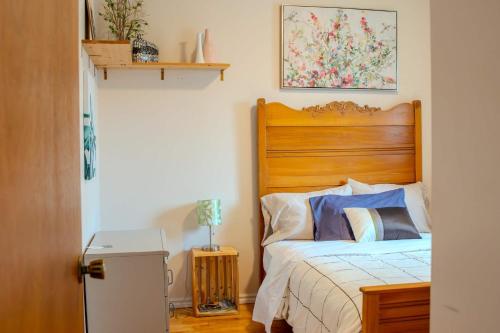 a bed with a wooden headboard in a bedroom at Logis du Bonheur in Rouyn