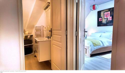 a small bedroom with a bed and a small desk at L'Écrin Appart in Villedieu-les-Poëles