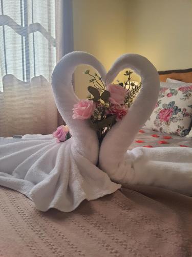 two swans made out of towels on a bed at Pousada Valle do Sol in Campos do Jordão