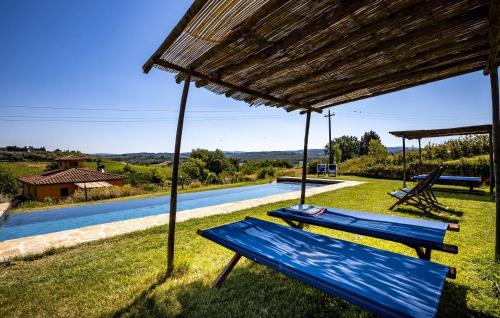 a blue bench sitting in the grass next to a pool at Amazing Home In Barberino Tavarnelle in Barberino di Val dʼElsa