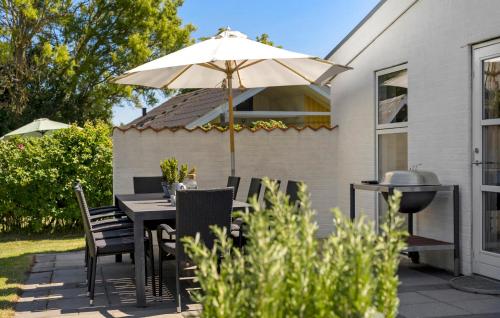 a patio with an umbrella and a table and chairs at Gorgeous Home In Sydals With Sauna in Neder Lysabild