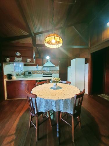 a kitchen with a table and chairs in a room at Chalés Valle do Sol in Campos do Jordão