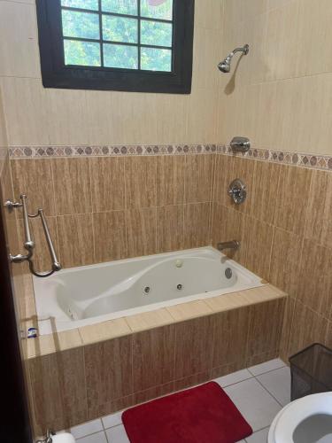 a bath tub in a bathroom with a sink at Hampton Hill La Loma - Escapada Natural, Santiago RD 