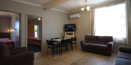 a living room with a couch and a table and chairs at Pelicans Motel San Remo in San Remo