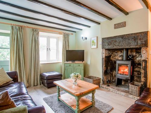a living room with a fireplace and a couch at Fern Cottage in Bradwell