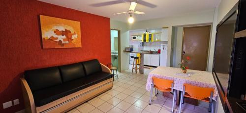 ein Wohnzimmer mit Sofa und Tisch in der Unterkunft Apartamento no Residencial Jardins das Thermas- Caldas Novas in Caldas Novas