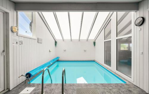 a swimming pool in a building with a skylight at Holiday Home Bjerregårdsvej Hvide Sande Ds Denm in Bjerregård