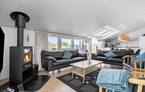 a living room with a couch and a fireplace at Holiday Home Bjerregårdsvej Hvide Sande Ds Denm in Bjerregård