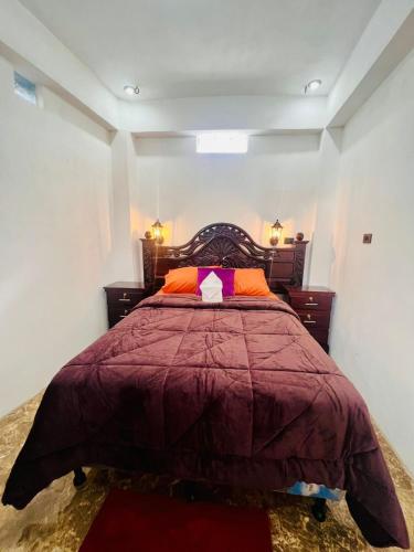a bedroom with a bed with a red comforter at Casa Don 20 in San Marcos La Laguna