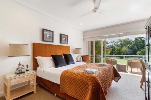 um quarto com uma cama grande e uma janela grande em Mirage Resort Villa 124 with access to Sheraton Facilities em Port Douglas
