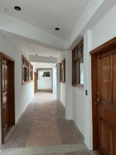 an empty hallway with a corridor with wooden doors and a hallwayngth at Casa Don 20 in San Marcos La Laguna