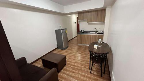 a small kitchen with a table and a refrigerator at Bayport West Naia Residences in Manila