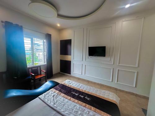 a living room with a couch and a tv on a wall at Motel TÂY HỒ in An Khê