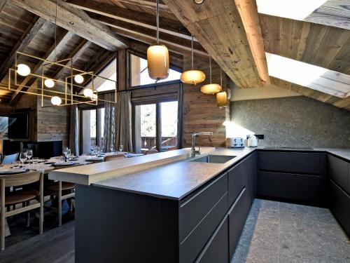 une grande cuisine avec un évier et une table dans l'établissement Penthouse Luxueux à Méribel avec SPA et Services Inclus - FR-1-613-32, à Méribel