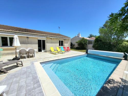 une piscine dans une cour avec des chaises et une maison dans l'établissement AGREABLE MAISON 2 CHAMBRES AVEC PISICINE ET STATIONNEMENT DANS UN QUARTIER CALME - FR-1-92-947, à Les Sables-dʼOlonne