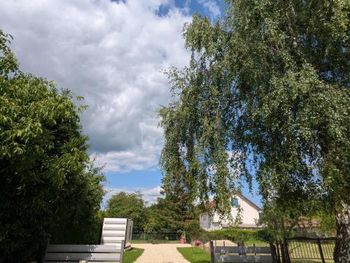 a white bench sitting in the middle of a yard at Gîte Moderne et Chaleureux pour 4 à Milly-sur-Bradon - FR-1-585-177 in Milly-sur-Bradon