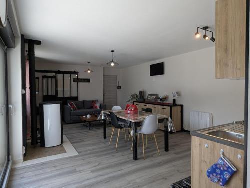 a kitchen and living room with a table and chairs at Gîte Moderne et Chaleureux pour 4 à Milly-sur-Bradon - FR-1-585-177 in Milly-sur-Bradon