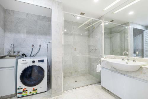 Un baño con lavadora y lavabo. en Mirage Resort Villa 130 with access to Sheraton Facilities, en Port Douglas