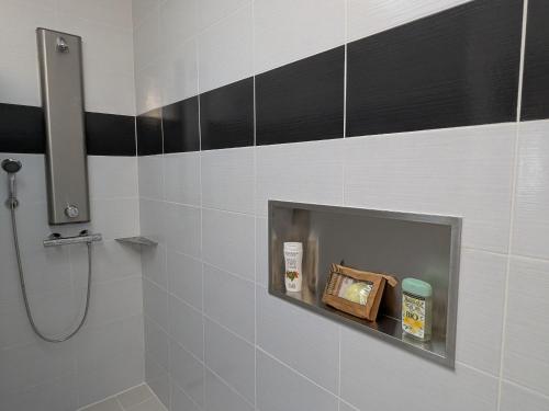 a bathroom with a shower with black and white tiles at Gîte Moderne et Chaleureux pour 4 à Milly-sur-Bradon - FR-1-585-177 in Milly-sur-Bradon