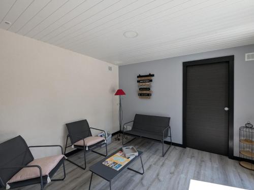 two chairs and a table in a room with a door at Gîte Moderne et Chaleureux pour 4 à Milly-sur-Bradon - FR-1-585-177 in Milly-sur-Bradon