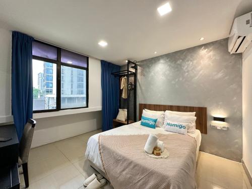 a hotel room with a bed and a window at Homigo - PWTC in Kuala Lumpur