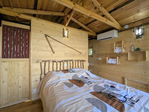 a bedroom with a bed in a wooden cabin at Cabane perchée romantique avec climatisation à St Paulien - FR-1-582-535 in Saint-Paulien