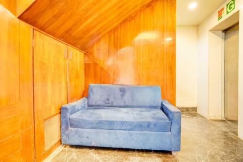 a blue chair sitting in the corner of a room at Hotel O Airport Road in Ahmedabad