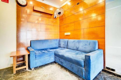 a blue couch in a room with a wooden wall at Hotel O Airport Road in Ahmedabad