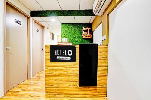 a hotel lobby with a hotel sign on the wall at Hotel O Vesu Surat in Surat