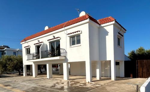 a white house with a red roof at Olive Bloom in Larnaka