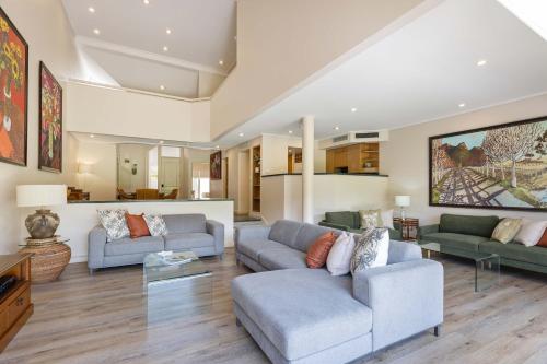 a living room with two couches and a table at Mirage Resort Villa 136 with access to Sheraton Facilities in Port Douglas