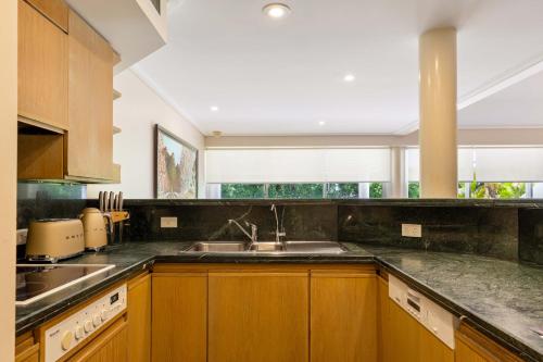 a kitchen with a sink and a large window at Mirage Resort Villa 136 with access to Sheraton Facilities in Port Douglas
