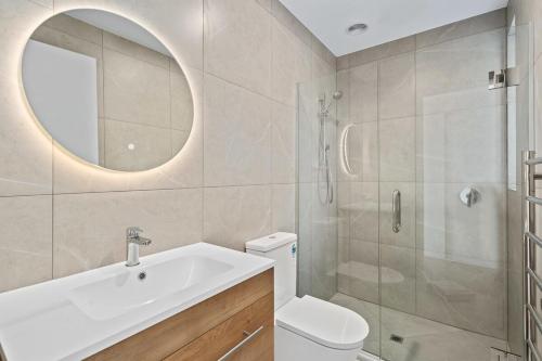 Un baño con inodoro, lavabo y espejo. en Stylish 1BR Escape Near Remarks, en Queenstown Airport