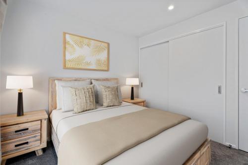 Un dormitorio con una cama con dos mesitas de noche y dos lámparas. en Stylish 1BR Escape Near Remarks, en Queenstown Airport